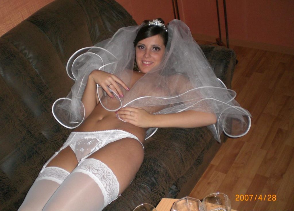 Невеста прикрывает обнаженную грудь фатой