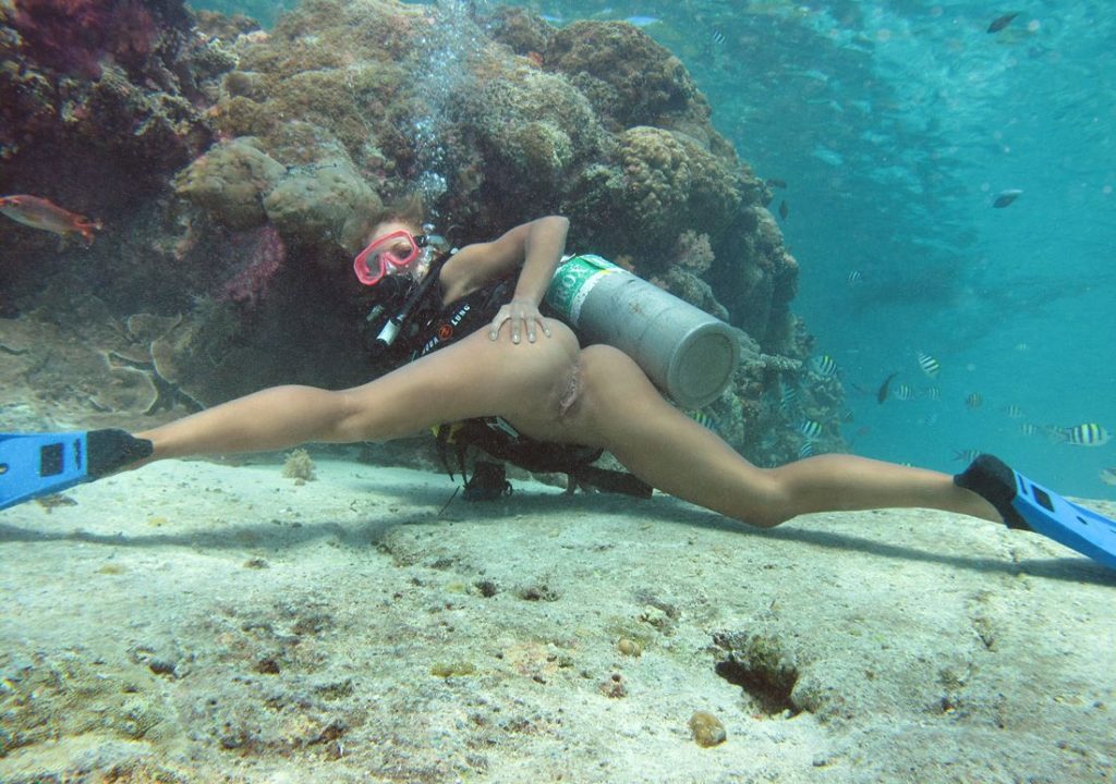 Голая девушка с аквалангом раздвигает ноги под водой