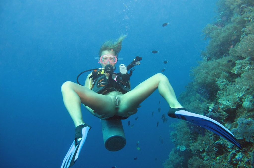 Девушка с аквалангом и в ластах показывает голую писю в море под водой